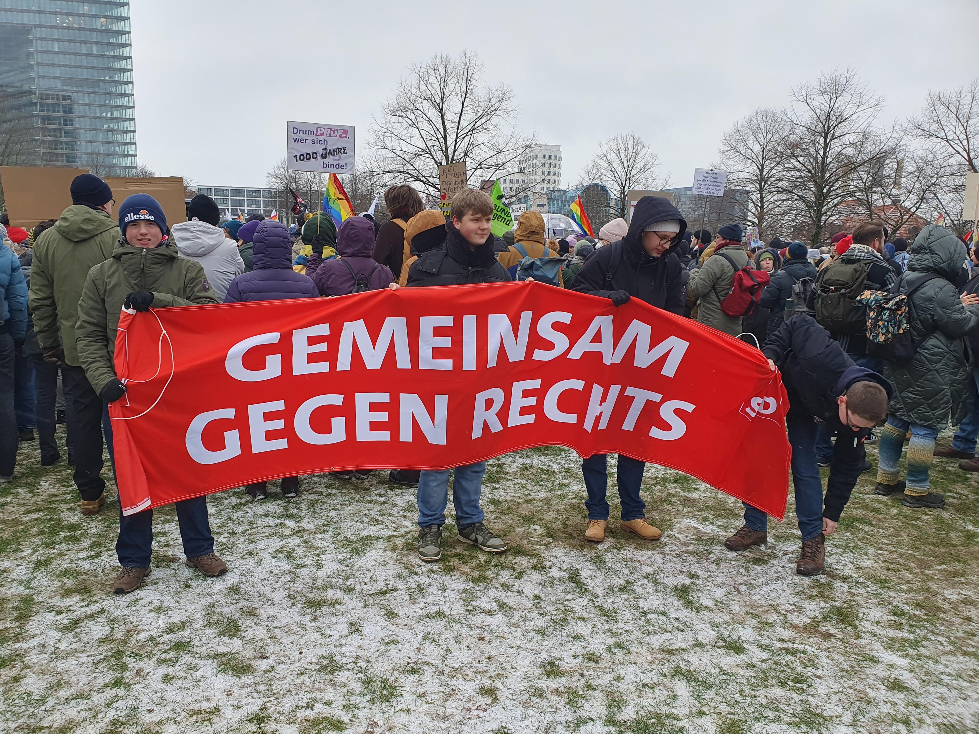 Eine Gruppe hält ein rotes Banner "GEMEINSAM GEGEN RECHTS"