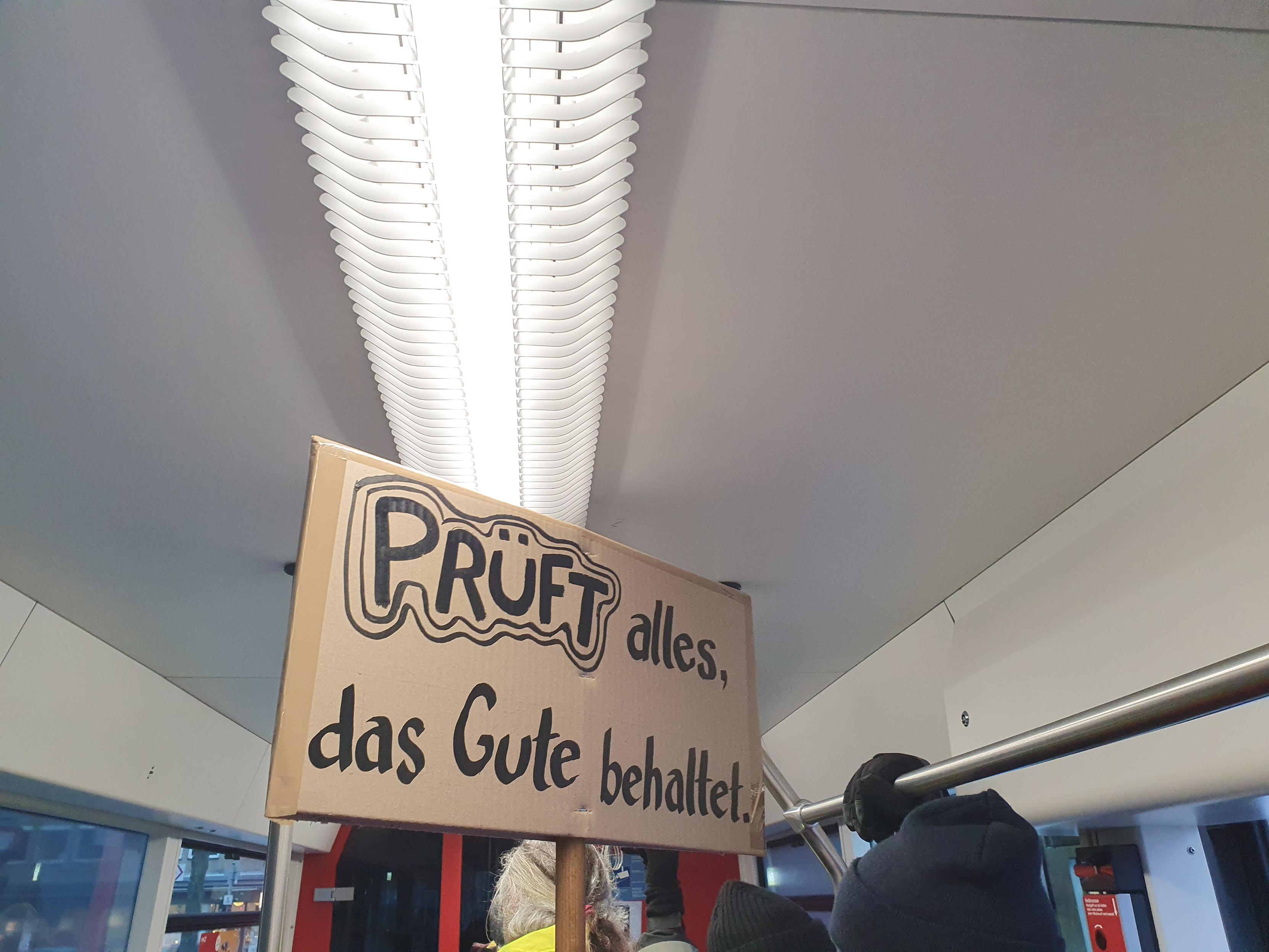 Ein Schild unter der U-Bahn Decke:PRÜFT alles, das Gute behaltet.